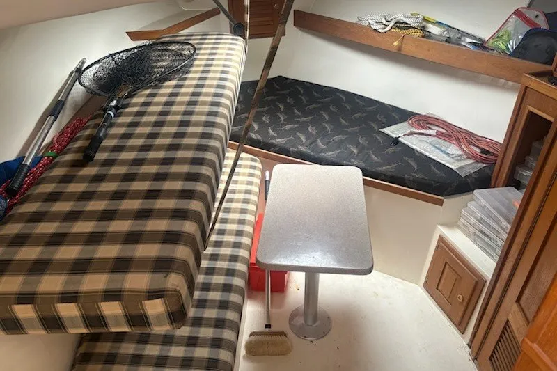 Slide: The Image of 2003 Albemarle 305 Express Fisherman cabin interior with seating, table, and fishing gear. - 26
