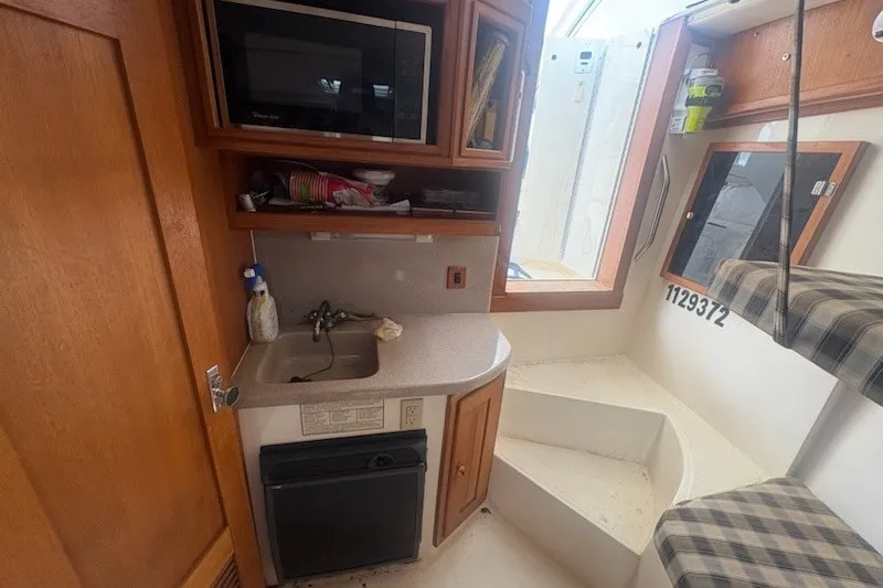 Slide: The Image of 2003 Albemarle 305 Express Fisherman interior with kitchenette, sink, and seating area. - 29