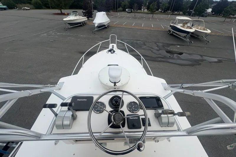 Slide: The Image of 2003 Albemarle 305 Express Fisherman boat helm with Raymarine controls in a parking lot. - 18
