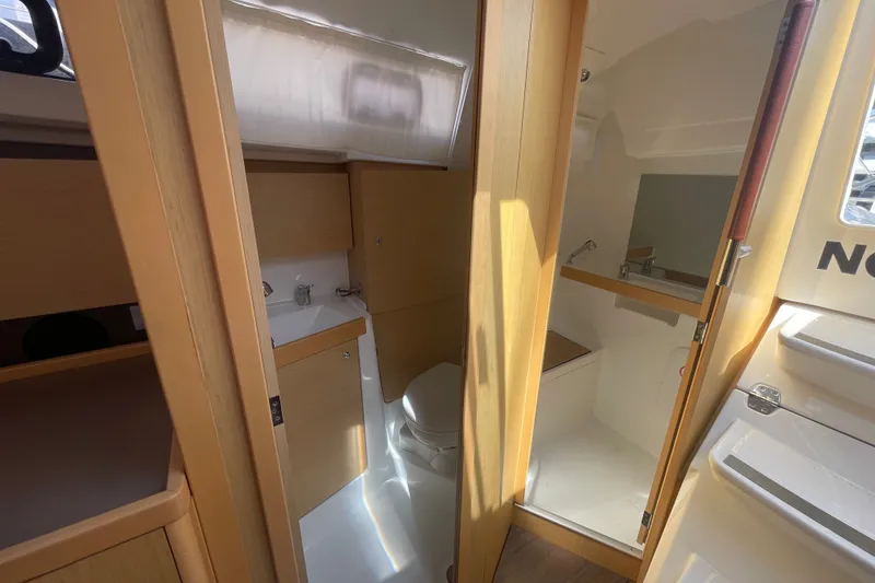 Slide: The Image of Interior of 2016 Beneteau Oceanis 35 yacht, featuring a compact bathroom with wooden accents. - 35