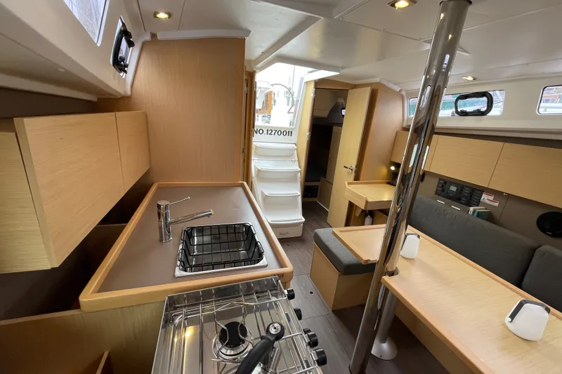 Slide: The Image of Interior of 2016 Beneteau Oceanis 35 sailboat, featuring modern kitchen and seating area. - 26