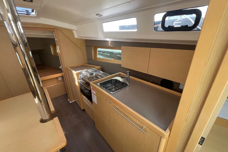 Slide: The Image of Interior of 2016 Beneteau Oceanis 35 yacht, featuring modern kitchen and wooden cabinetry. - 27