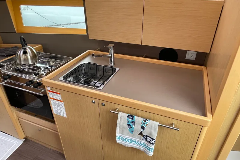 Slide: The Image of Modern kitchen area in a 2016 Beneteau Oceanis 35 yacht, featuring a sink and stove. - 29