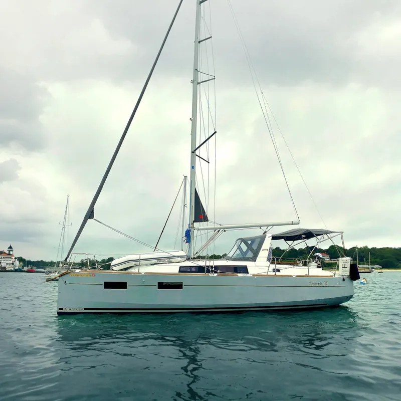 The Image of 2016 Beneteau Oceanis 35 sailboat anchored on calm water, overcast sky. - 0