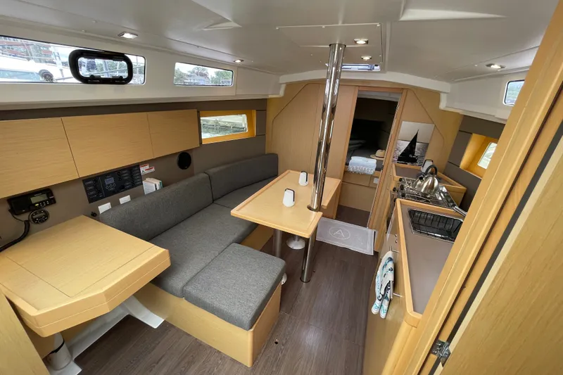 Slide: The Image of Interior of 2016 Beneteau Oceanis 35 sailboat with modern furnishings and compact kitchen. - 24