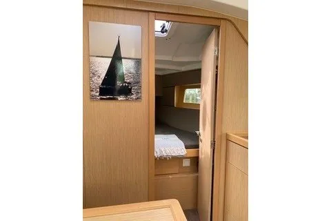 Slide: The Image of Interior cabin of 2016 Beneteau Oceanis 35 sailboat, featuring wooden finish and cozy sleeping area. - 32
