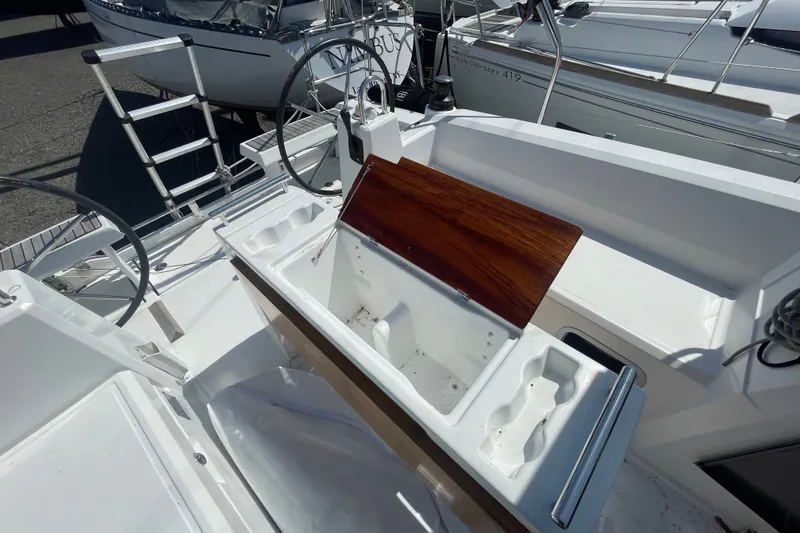 Slide: The Image of 2016 Beneteau Oceanis 35 cockpit with dual steering wheels and wooden hatch cover. - 10