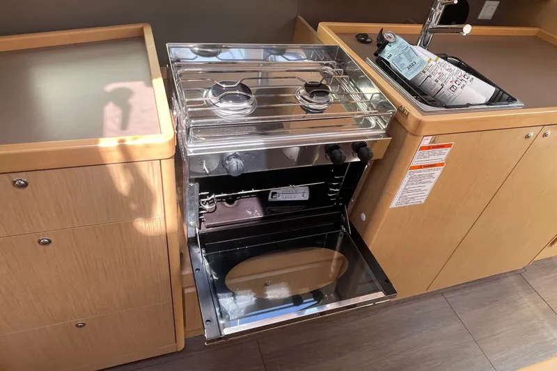 Slide: The Image of Compact kitchen area in a 2016 Beneteau Oceanis 35 sailboat with stove and sink. - 30