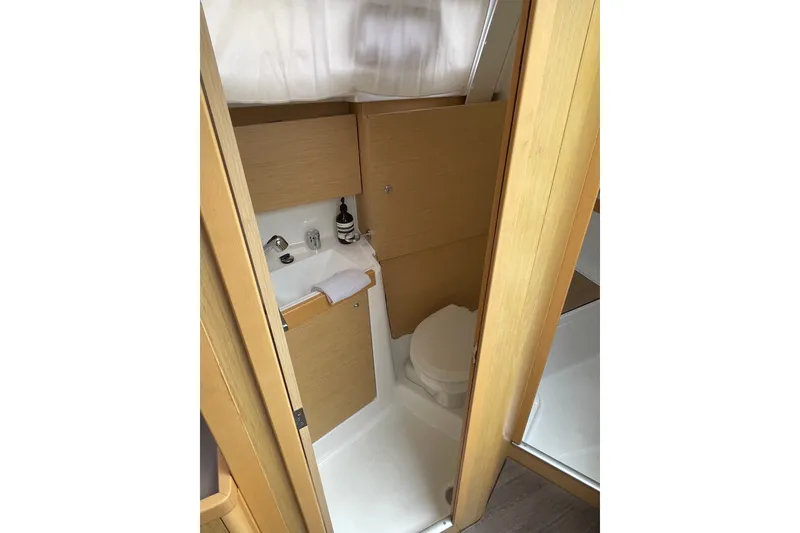 Slide: The Image of Compact bathroom in 2016 Beneteau Oceanis 35 sailboat, featuring wooden cabinetry and modern fixtures. - 36