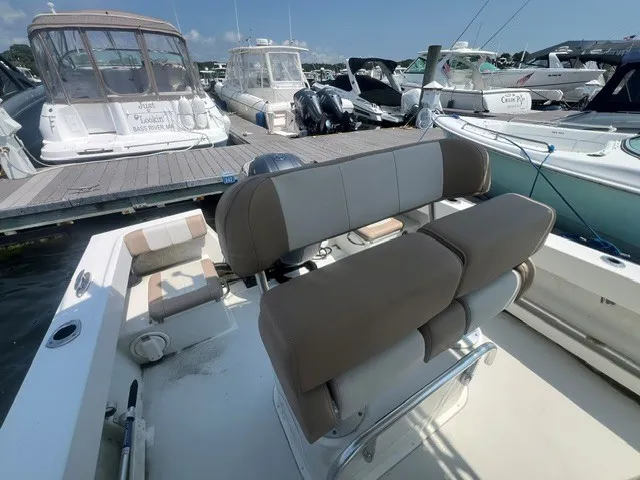 Slide: The Image of A 2018 Parker 2100 Deep Vee with beige and white seating area, docked alongside other boats. - 6