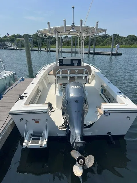Slide: The Image of A 2018 Parker 2100 Deep Vee boat docked. It features an outboard motor. - 1