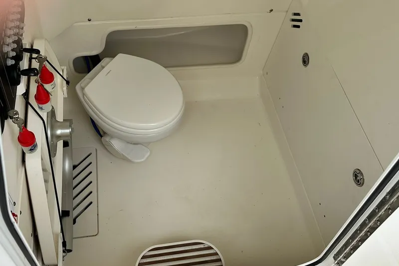 Slide: The Image of 2024 Boston Whaler 250 Outrage boat interior with marine toilet and storage area. - 22