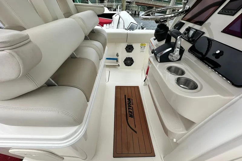 Slide: The Image of 2024 Boston Whaler 250 Outrage boat interior with helm, seating, and cup holders. - 16