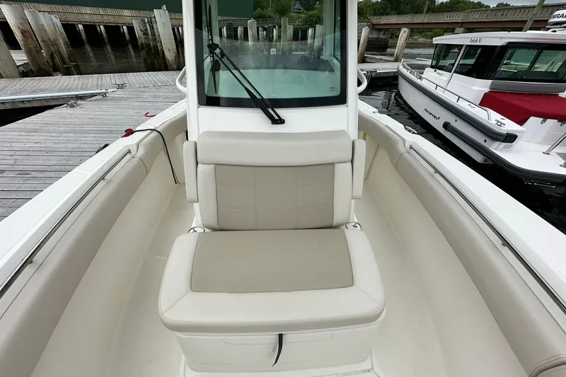 Slide: The Image of 2024 Boston Whaler 250 Outrage boat interior with cushioned seating at dock. - 19