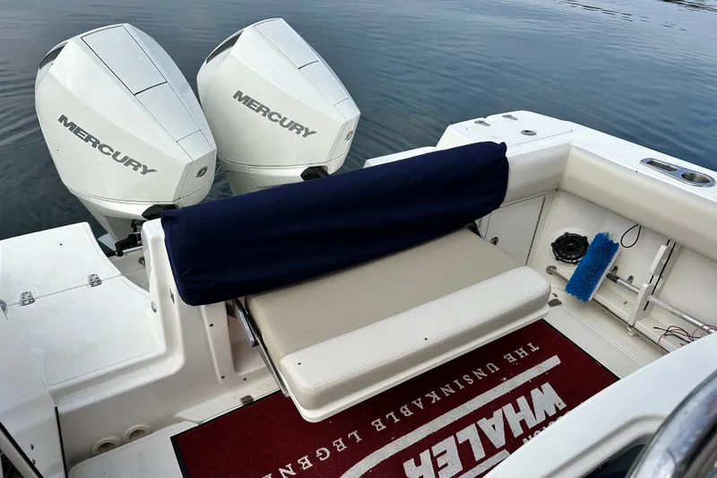 Slide: The Image of 2024 Boston Whaler 250 Outrage boat with dual Mercury engines, featuring a cushioned seating area. - 18