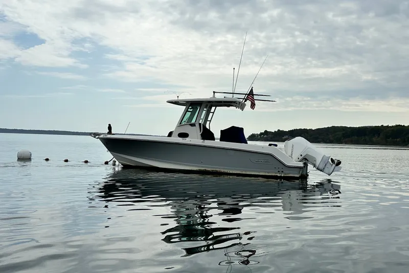 The Image of 2024 Boston Whaler 250 Outrage boat on calm water under cloudy sky. - 0