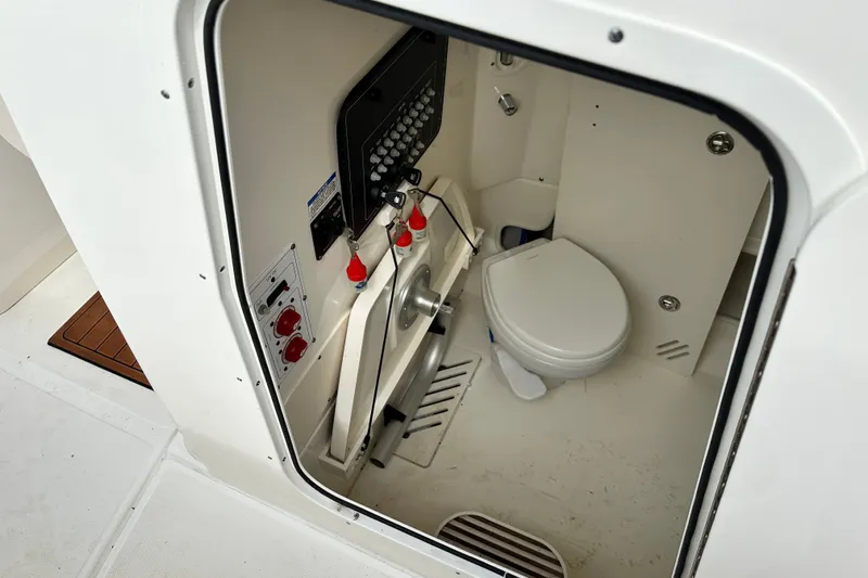 Slide: The Image of 2024 Boston Whaler 250 Outrage boat interior with compact marine toilet. - 23