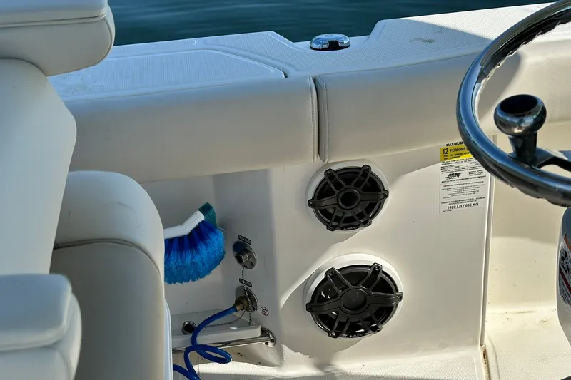 Slide: The Image of 2024 Boston Whaler 250 Outrage boat interior with speakers and steering wheel. - 12