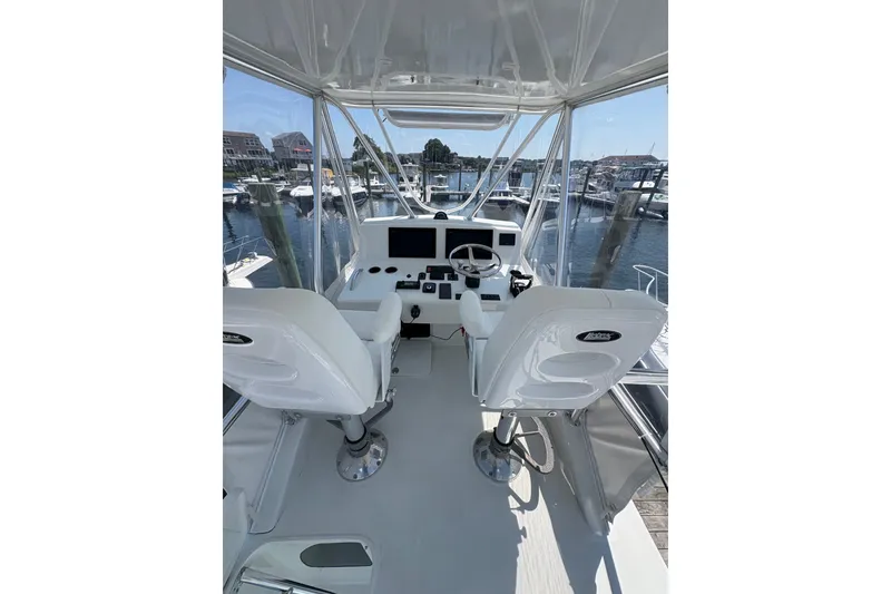 Slide: The Image of 2023 Millenium 37 Walk Around Fly Bridge Sportfish interior with helm and marina view. - 25