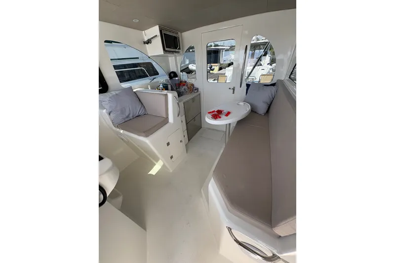 Slide: The Image of Interior of 2023 Millenium 37 Walk Around Fly Bridge Sportfish, featuring seating and compact kitchenette. - 49