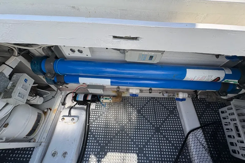 Slide: The Image of Engine compartment of 2023 Millenium 37 Walk Around Fly Bridge Sportfish, featuring blue filtration system. - 30