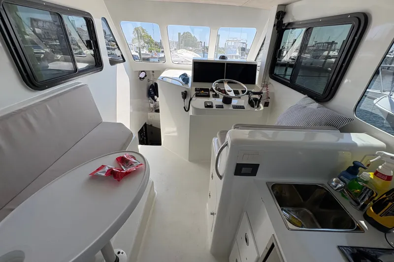Slide: The Image of Interior of 2023 Millenium 37 Walk Around Fly Bridge Sportfish boat, featuring helm and seating area. - 15
