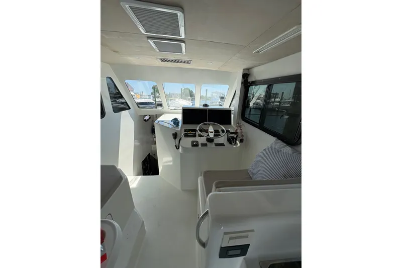Slide: The Image of Interior of 2023 Millenium 37 Walk Around Fly Bridge Sportfish boat, featuring helm and seating area. - 44
