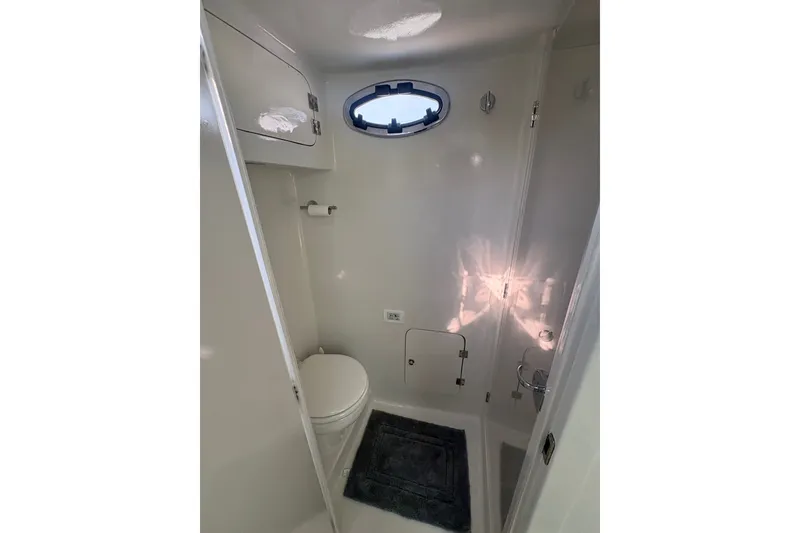 Slide: The Image of 2023 Millenium 37 Walk Around Fly Bridge Sportfish boat bathroom interior with porthole window. - 56