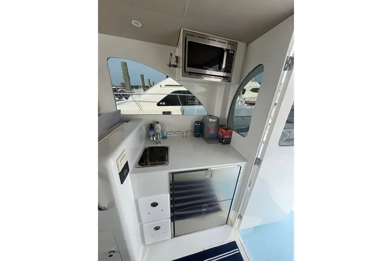 Slide: The Image of 2023 Millenium 37 Walk Around Fly Bridge Sportfish interior with kitchenette and appliances. - 58