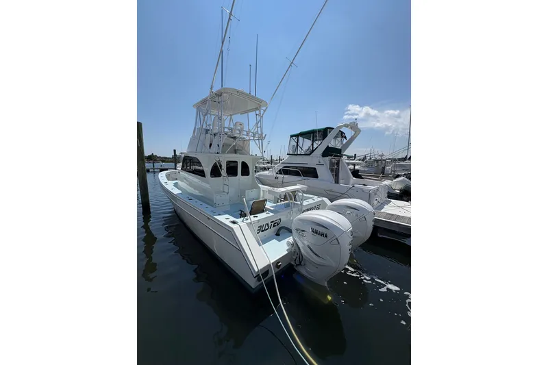 Slide: The Image of 2023 Millenium 37 Walk Around Fly Bridge Sportfish boat docked at marina. - 22