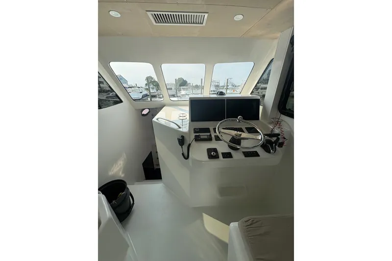 Slide: The Image of Interior helm of 2023 Millenium 37 Walk Around Fly Bridge Sportfish, featuring modern controls and steering. - 57