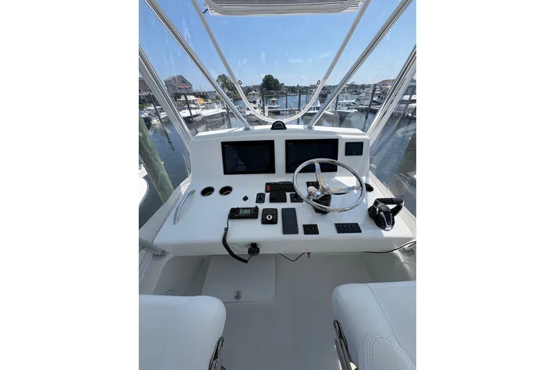 Slide: The Image of 2023 Millenium 37 Walk Around Fly Bridge Sportfish helm with modern controls and marina view. - 24