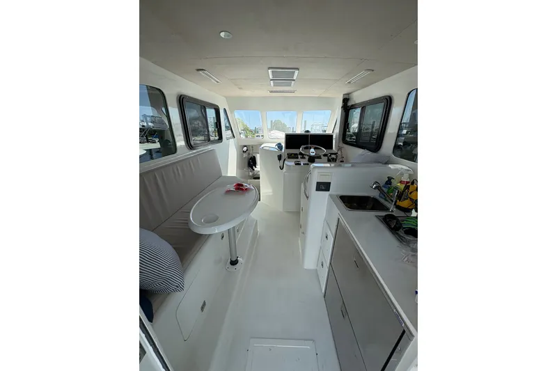 Slide: The Image of Interior of 2023 Millenium 37 Walk Around Fly Bridge Sportfish boat, featuring seating and kitchenette. - 33