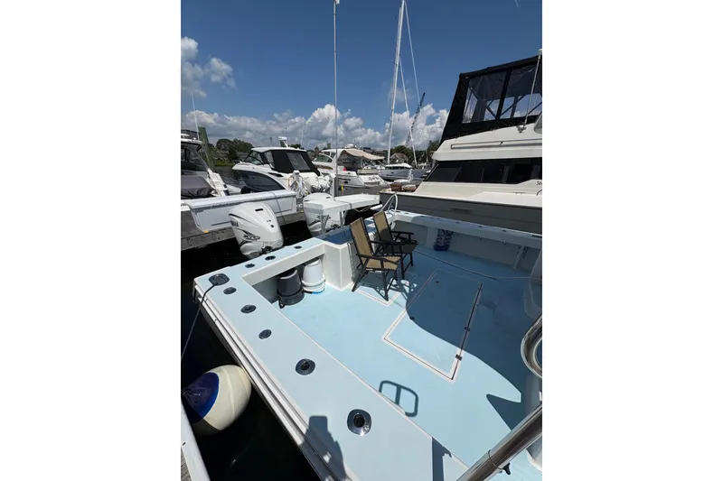 Slide: The Image of 2023 Millenium 37 Walk Around Fly Bridge Sportfish at marina, featuring spacious deck area. - 47