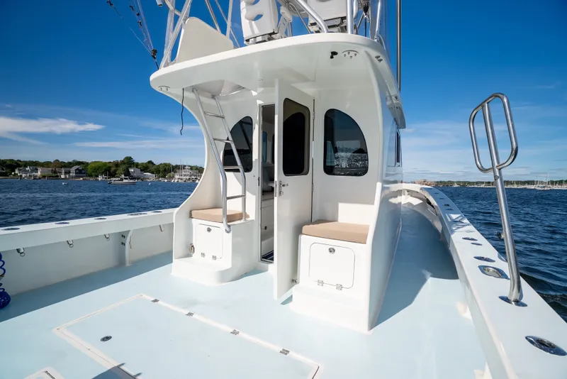 Slide: The Image of 2023 Millennium Marine 37 Walk Around Fly Bridge Sportfish on calm waters, showcasing spacious deck. - 82