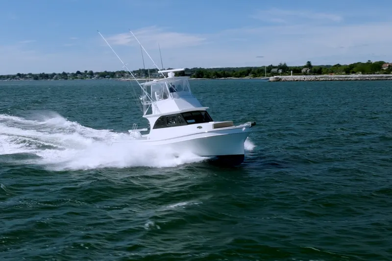 Slide: The Image of 2023 Millennium Marine 37 Walk Around Fly Bridge Sportfish cruising on open water. - 103