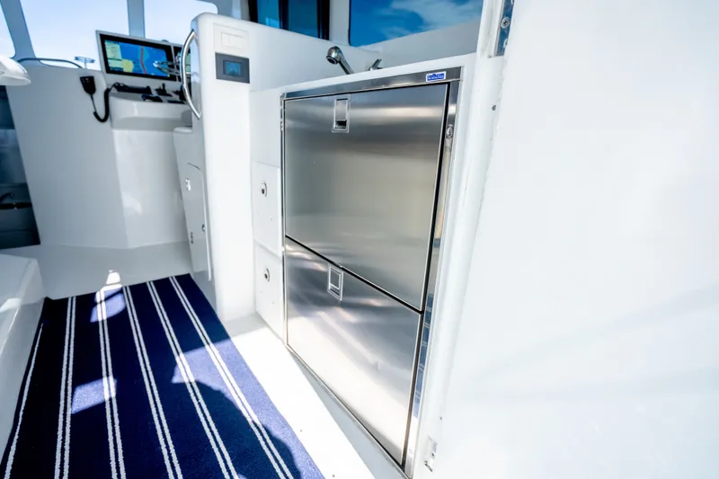 Slide: The Image of 2023 Millennium Marine 37 Walk Around Fly Bridge Sportfish interior with stainless steel appliances. - 91