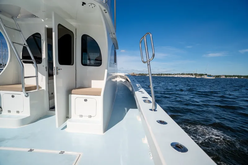 Slide: The Image of 2023 Millennium Marine 37 Walk Around Fly Bridge Sportfish on open water, showcasing deck and cabin. - 88