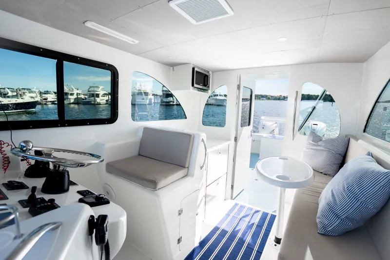 Slide: The Image of Interior of 2023 Millennium Marine 37 Walk Around Fly Bridge Sportfish, featuring modern seating and windows. - 94