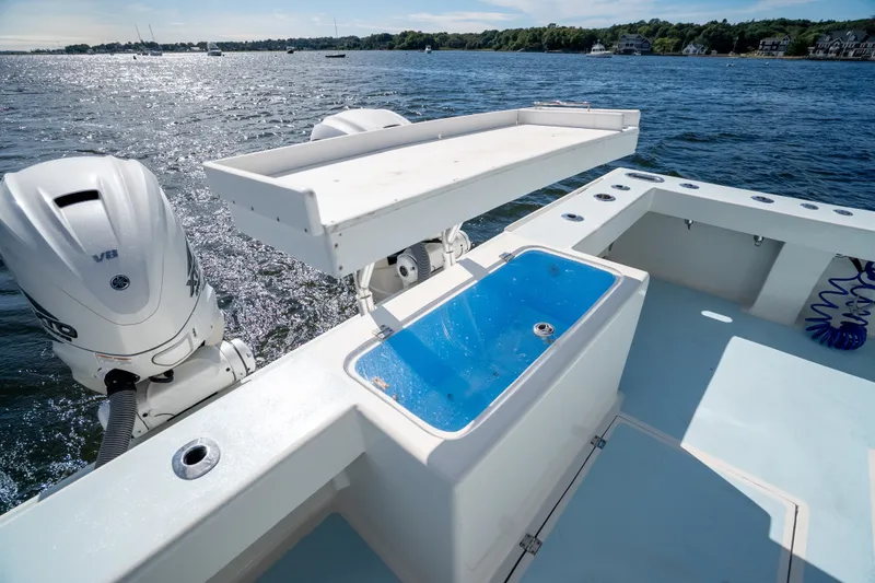 Slide: The Image of 2023 Millennium Marine 37 Walk Around Fly Bridge Sportfish on water, featuring dual outboard engines. - 83