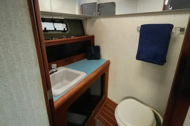 Slide: The Image of 1988 Bayliner 3818 Motoryacht bathroom with sink, toilet, and towel rack. - 46