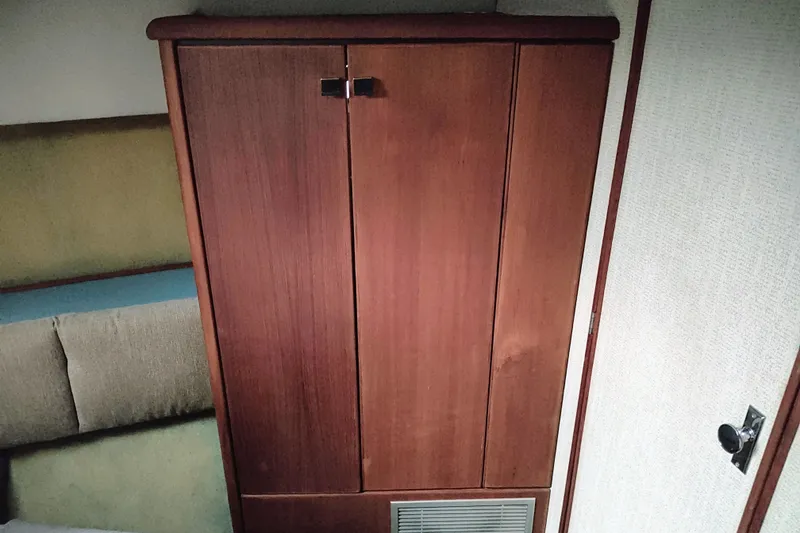 Slide: The Image of Wooden cabinet inside 1988 Bayliner 3818 Motoryacht, featuring dual doors and a vented panel. - 44