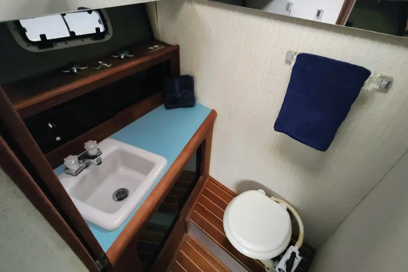 Slide: The Image of The image shows a bathroom on a 1988 Bayliner 3818 Motoryacht with a sink and toilet. - 45