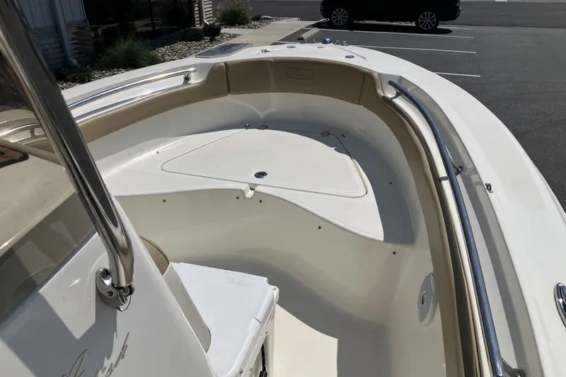 Slide: The Image of 2017 Pioneer 202 Sportfish boat interior with seating and storage, parked in a lot. - 12