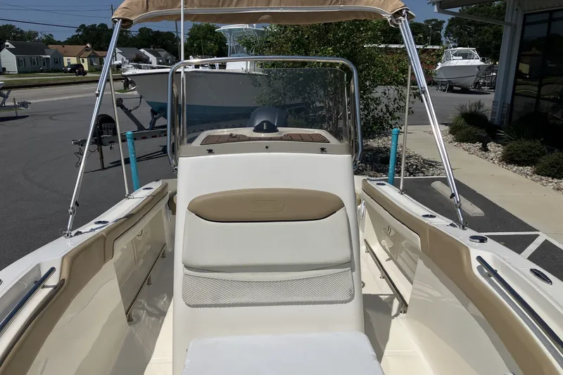 Slide: The Image of 2017 Pioneer 202 Sportfish boat interior with seating and console, parked outdoors. - 10