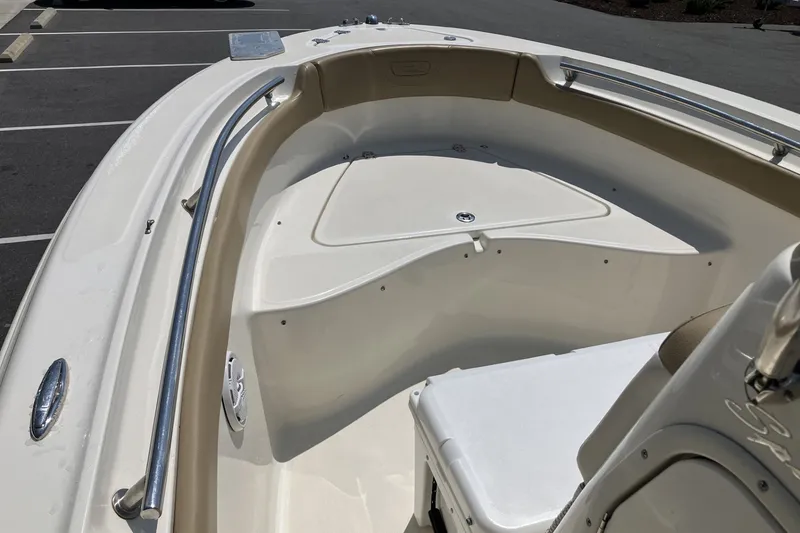 Slide: The Image of 2017 Pioneer 202 Sportfish boat interior with seating and storage, parked in a lot. - 11