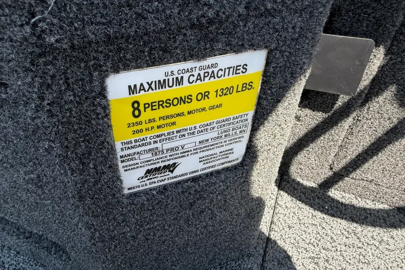 Slide: The Image of Capacity label on 2027 Lund 1875 Pro-V boat, indicating 8-person or 1320 lbs limit. - 23