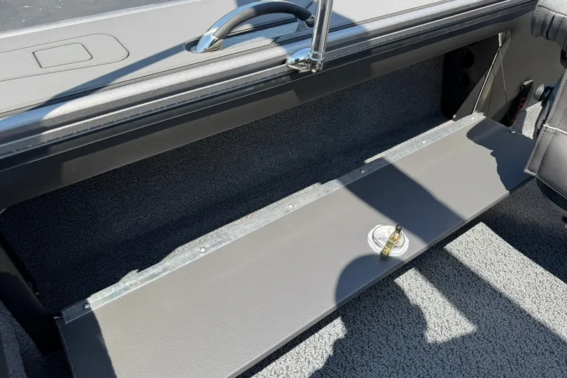 Slide: The Image of Interior of 2027 Lund 1875 Pro-V boat showing storage compartment and handle. - 21