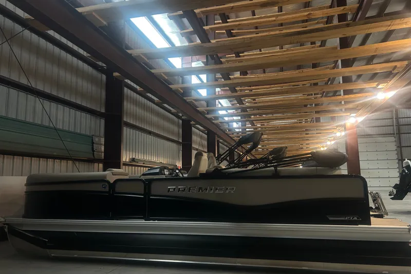 Slide: The Image of 2027 Premier 230 Sunsation RF - CL pontoon boat in a spacious indoor storage facility. - 1