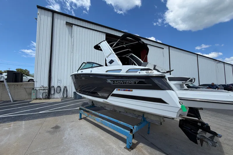 Slide: The Image of 2023 Monterey 258SS Super Sport boat displayed outdoors near a large warehouse. - 1